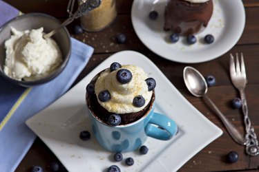 High-protein mug cake with blueberries on white plate on table