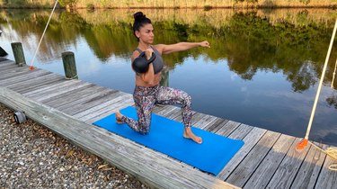 Fit woman doing a full-body kettlebell workout outdoors