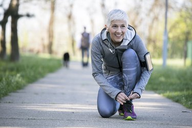 older woman with gray hair in the early sixties relaxing after sport training