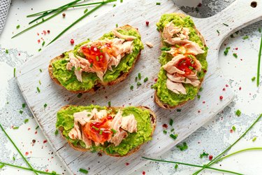 Homemade Toast sandwich with Salmon, Avocado and chilli jam on wihte wooden board. healthy food