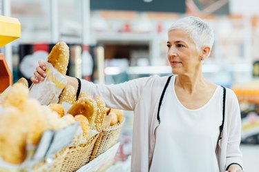 Mature Woman Groceries Shopping for foods for gluten free symbol