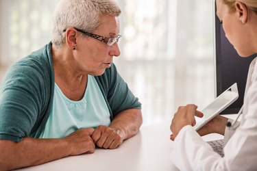 Doctor showing test results on tablet to her patient