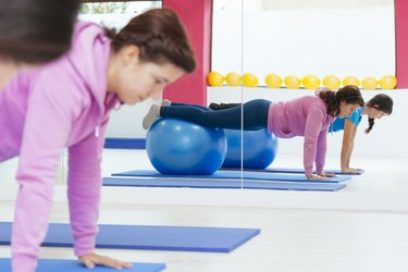 healthy women doing crunches with a yoga ball.