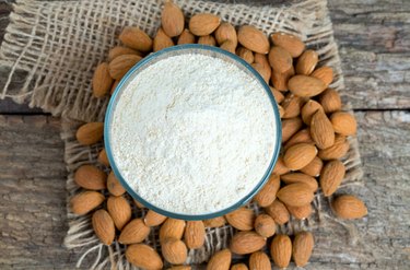 Almonds and almond flour on wooden surface