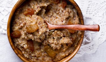 Oatmeal with flax seeds and raisins in a wooden bowl