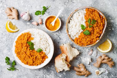 Traditional red lentil Dal. Indian Dhal spicy curry in bowl with flat bread and spices. Top view, overhead