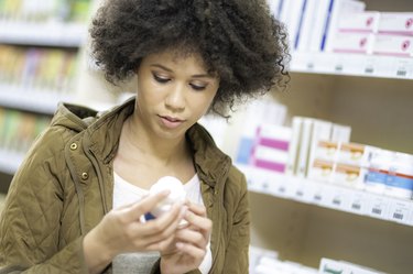 A young woman looking at supplements in a pharmacy
