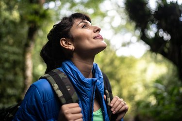 Young woman hiking in a forest, as a way to cope with chronic fatigue syndrome