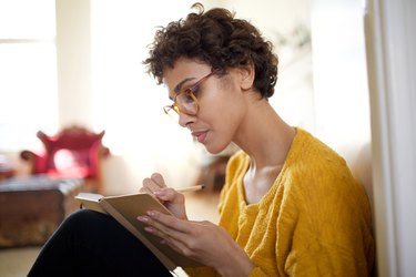 A young woman practices gratitude by writing in a journal