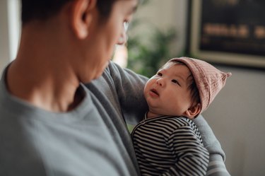 close up of parent holding their newborn baby, supporting their loved one with postpartum depression