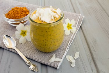 Pudding with chia,turmeric and coconut chips on the gray napkin