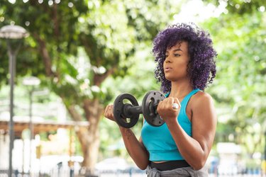 Person doing a dumbbell biceps curl outside