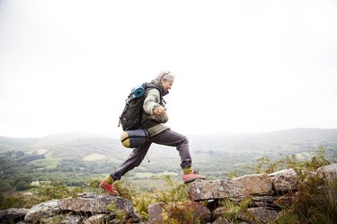 woman hiking outside with backpack to lower blood pressure