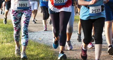lower bodies of marathon runners wearing race bibs