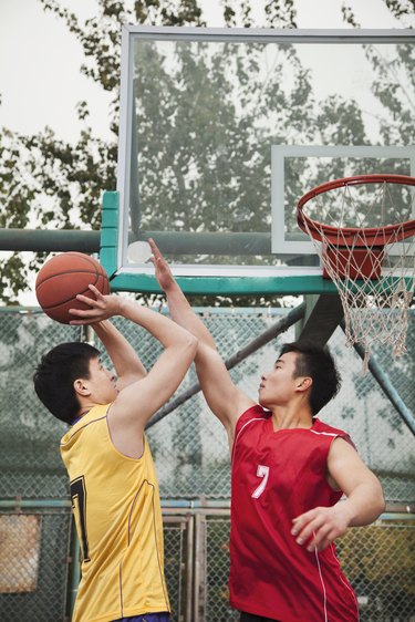 Two people playing basket ball