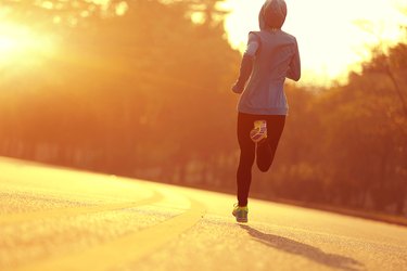 young fitness woman runner athlete running at  sunrise road